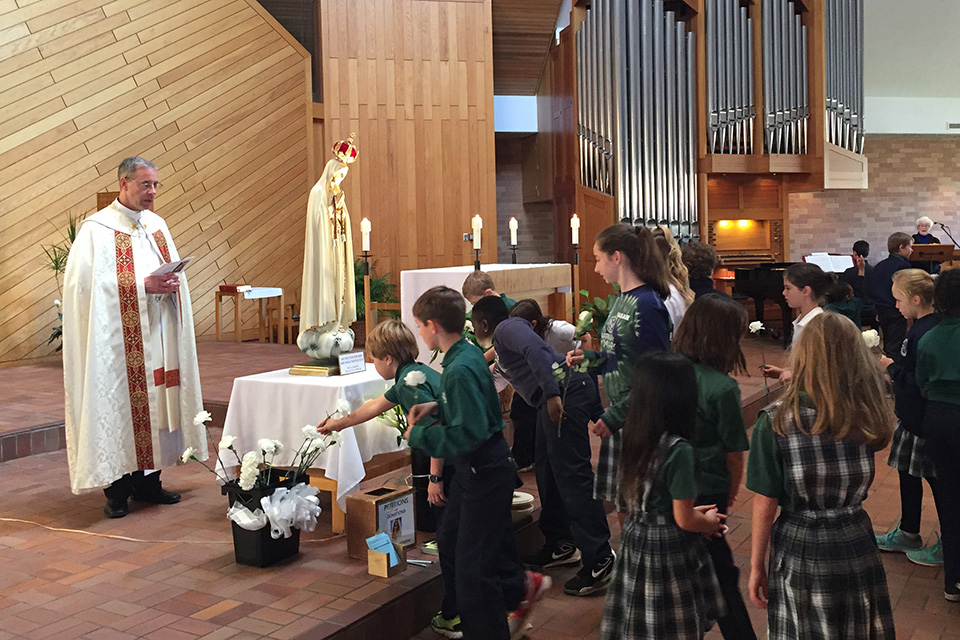 Children approach the statue of Our Lady of Fatima at a tour stop in Minnesota